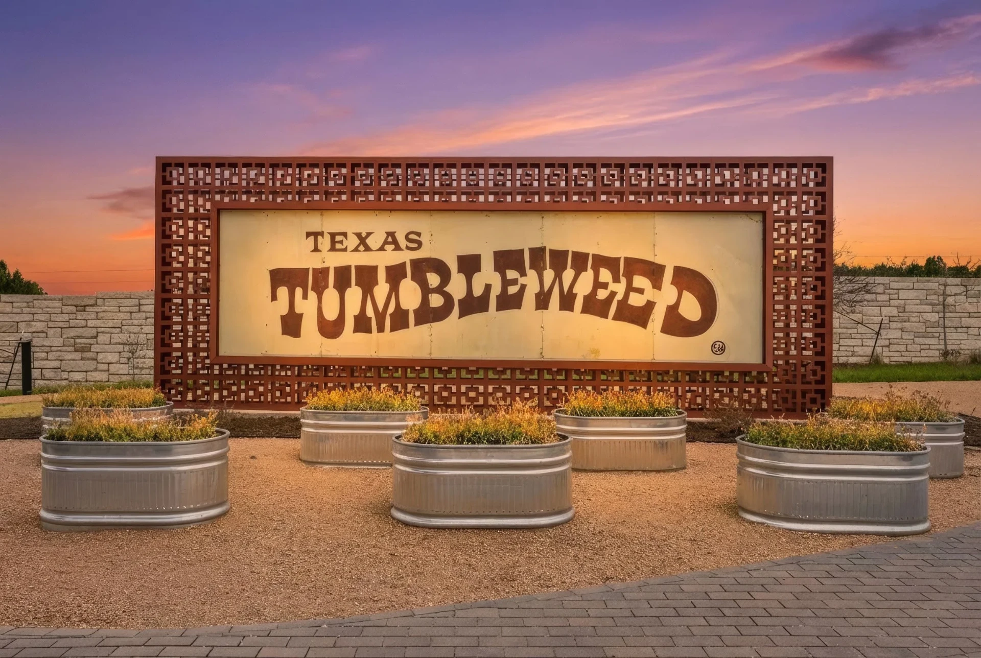 Restored Texas Tumbleweed tin sign at the heart of the VUE community garden